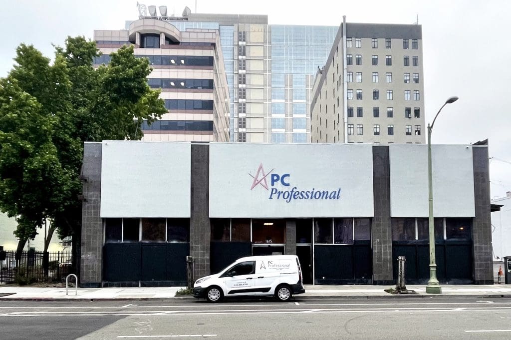 Two PC Professional technicians checking hardware inventory and paperwork in a storage room
