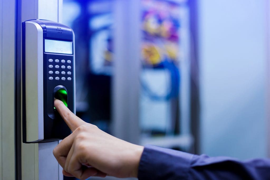 A person scanning their fingerprint on a machine to gain access to a server room.